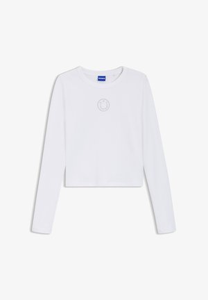 White long-sleeve cropped top with round neckline, small dotted smiley face design near the chest, and blue HUGO label inside collar.