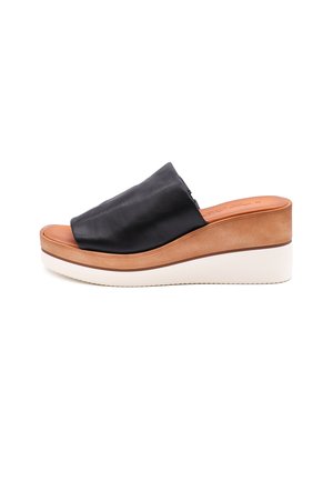 Infradito in pelle nera con tomaia testurizzata, piattaforma beige e suola in gomma bianca. Presenta contorni morbidi e dettagli minimi.