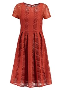 Robe couleur rouille longueur genou, manches courtes, motif en dentelle géométrique sur toute la surface, avec col rond et jupe plissée.