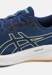 Marine hardloopschoen met een gestructureerde mesh bovenkant, beige accenten en een witte FlyteFoam tussenzool, ontworpen voor lichtgewicht comfort.