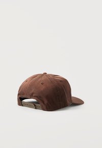 Καφέ ρυθμιζόμενο καπέλο μπέιζμπολ, εμφανιζόμενο από την πίσω πλευρά με πλαστικό καπάκι κλεισίματος, σε λευκό απλό φόντο.