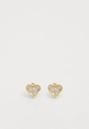 Gold heart-shaped earrings featuring clear, faceted synthetic stones. The design includes a small top accent above each heart.