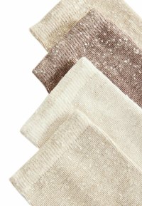 Set od četiri čarape s reljefnim rebrima u bojama bež, svijetlosmeđa, taupe i krem, s mrljastim uzorcima i mekanim, rastezljivim materijalom.