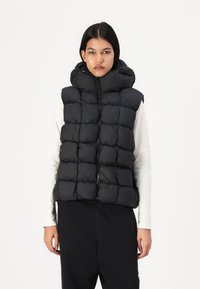 Melnas pūkām veste ar izšūtu dizainu, augstu apkakli un priekšējo rāvējslēdzēju, kas ir viegla, pildīta tekstūra, lai nodrošinātu siltumu un komfortu.