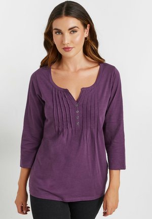 Paarse, lange mouwen shirt met een diepe V-hals, voorzien van verticale plooien en een vijfknopen-sluiting. Zachte, lichtgewicht stof.