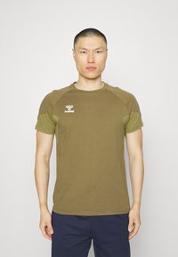 T-shirt en coton olive avec des manches courtes contrastantes et un col rond ; arbore un logo blanc sur le haut à gauche de la poitrine.