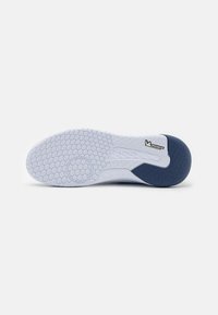 Hvid atletisk skosål med en hexagonal tekstur, prydet med en blå accent og "Kempa"-logo, samt en Michelin-brandingdetalje.