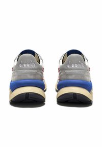 Sneaker con una toma in suede grigio, con una suola intermedia blu in contrasto e dettagli rossi. Presenta il logo sul tallone e un pannello posteriore testurizzato. Suola piatta nera.