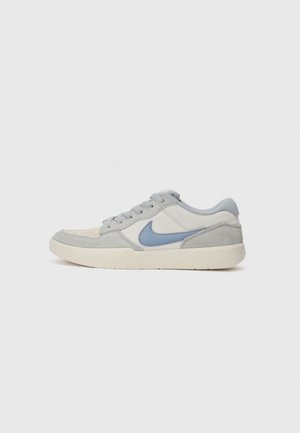 Tenis gri, cu un amestec de nubuc și piele, accente bleu deschis, vârf rotund, design aplatizat cu șireturi și talpă texturată din cauciuc.