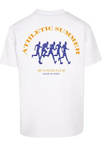 Hvid bomulds t-shirt med rund hals. Har et blåt grafisk design af løbende figurer og orange tekst: "ATHLETIC SUMMER RUNNING CLUB MADE IN PARIS."