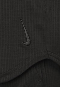 Czarne sportowe szorty wykonane z teksturowanej tkaniny, z małym czarnym logo Nike i starannym wykończeniem szwu wzdłuż dołu.