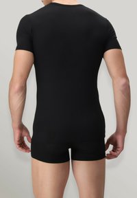 Maglietta nera a maniche corte aderente e pantaloni corti abbinati. Tessuto liscio con una consistenza morbida. Design semplice e senza cuciture, privo di decorazioni.