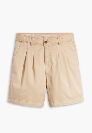 Shorts plissés beige avec poches avant, passants pour ceinture et fermeture par bouton à la taille.