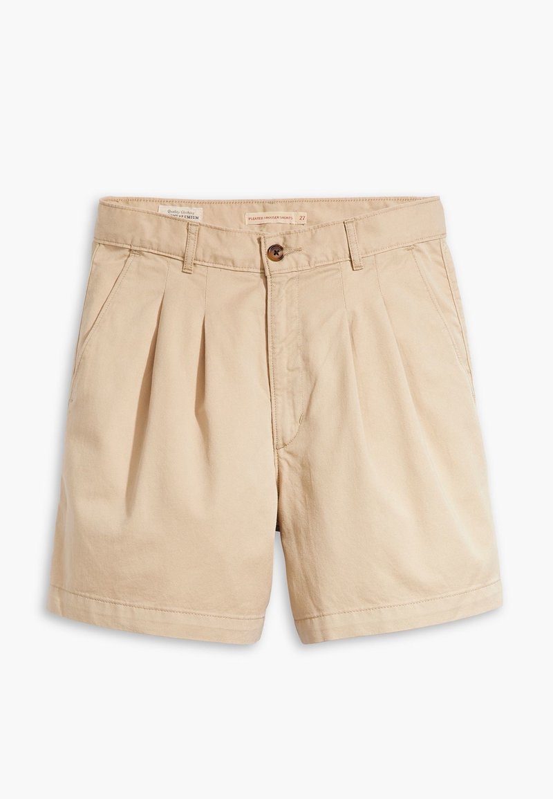 Shorts plissés beige avec poches avant, passants pour ceinture et fermeture par bouton à la taille.