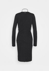 Robe noire à manches longues avec fronces et une silhouette ajustée. Décorée de pois dorés sur toute la surface, dotée d'un dos échancré et d'une fermeture éclair.