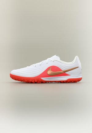 Chaussure de sport blanche à profil bas avec semelle rouge et accents, présentant un swoosh Nike métallique cuivre sur le côté.