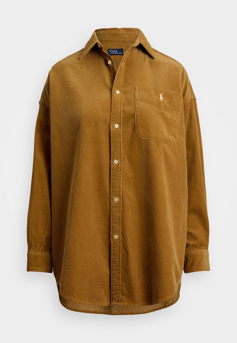 Camisa de pana marrón con cuello abotonado, bolsillo delantero y logo bordado. Presenta acanalado vertical y mangas largas.