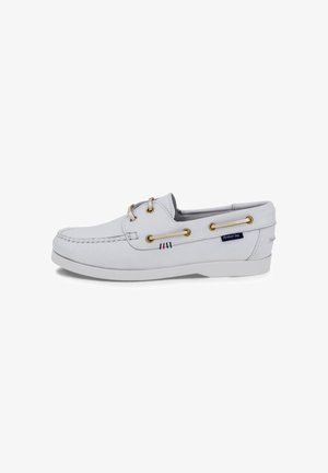 Witte leren bootschoen met mocassin-stiksel, beige veters door gouden oogjes en een "Armor lux" stoffen label aan de zijkant.