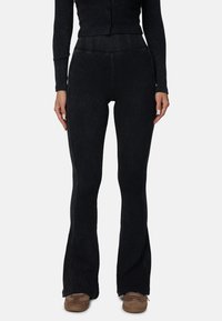 Zwarte flared broeken met een ribbeltextuur, voorzien van zijpaneelaccenten, brede beenopeningen en een hoge taille.