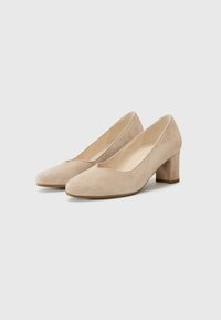 Beige semskede pumps med rund tå og lav blokkheel. Glatt tekstur med minimale sømmer og en klassisk silhuett.