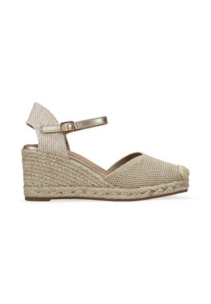 Sandalia espadrile de cuña tejida en beige con tira en el tobillo y hebilla, suela trenzada de yute y punta cerrada.