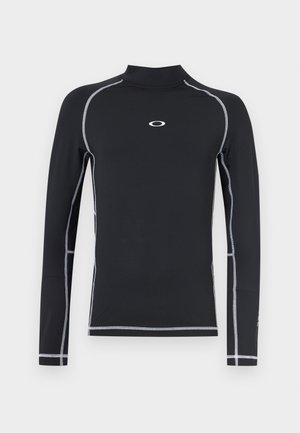 Črna športna majica z dolgimi rokavi z belo kontrastno vezenino in majhnim belim ovalnim logotipom na sredini prsnega dela.
