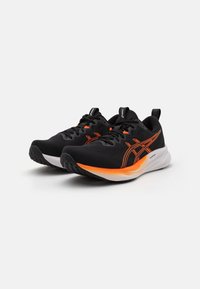 Black athletic shoes with mesh upper, orange accents, cushioned white midsole, and black rubber outsole. Features laces and pull tab.
