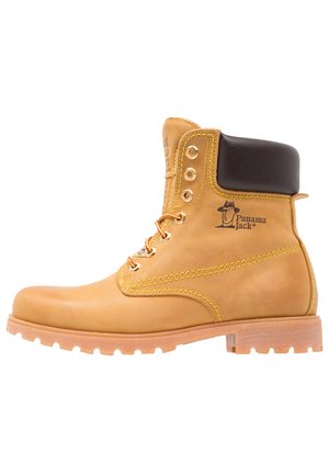 Stivale in pelle marrone chiaro con un colletto imbottito nero, occhielli in metallo e cuciture arancioni. Presenta una suola robusta e il marchio Panama Jack.