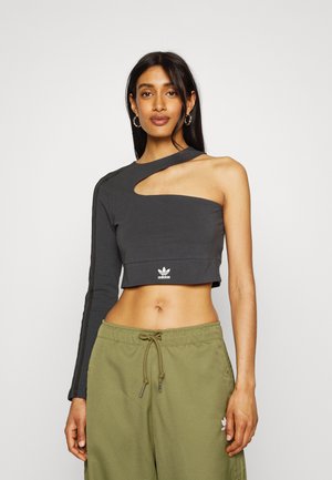 Top lungo a maniche lunghe grigio scuro, corto e con ritaglio asimmetrico sulla spalla sinistra, con logo bianco Adidas in basso.