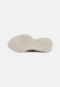 Sko såle med et teksturert, bølget mønster i lys beige med en subtil glansfinish, designet for grep og stabilitet.