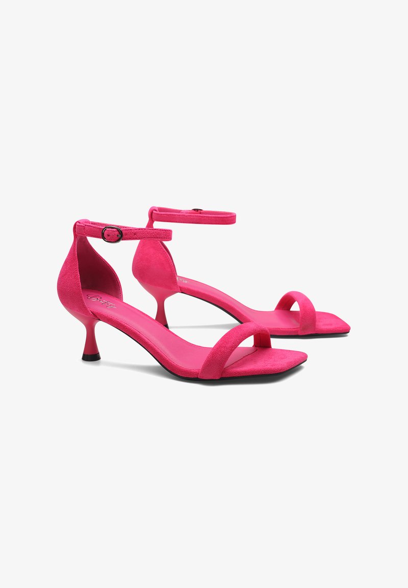 Sandali con tacco alto in pelle scamosciata rosa dal design elegante, con cinturino alla caviglia regolabile e punta affusolata. Presentano un tacco sottile e una suola liscia.