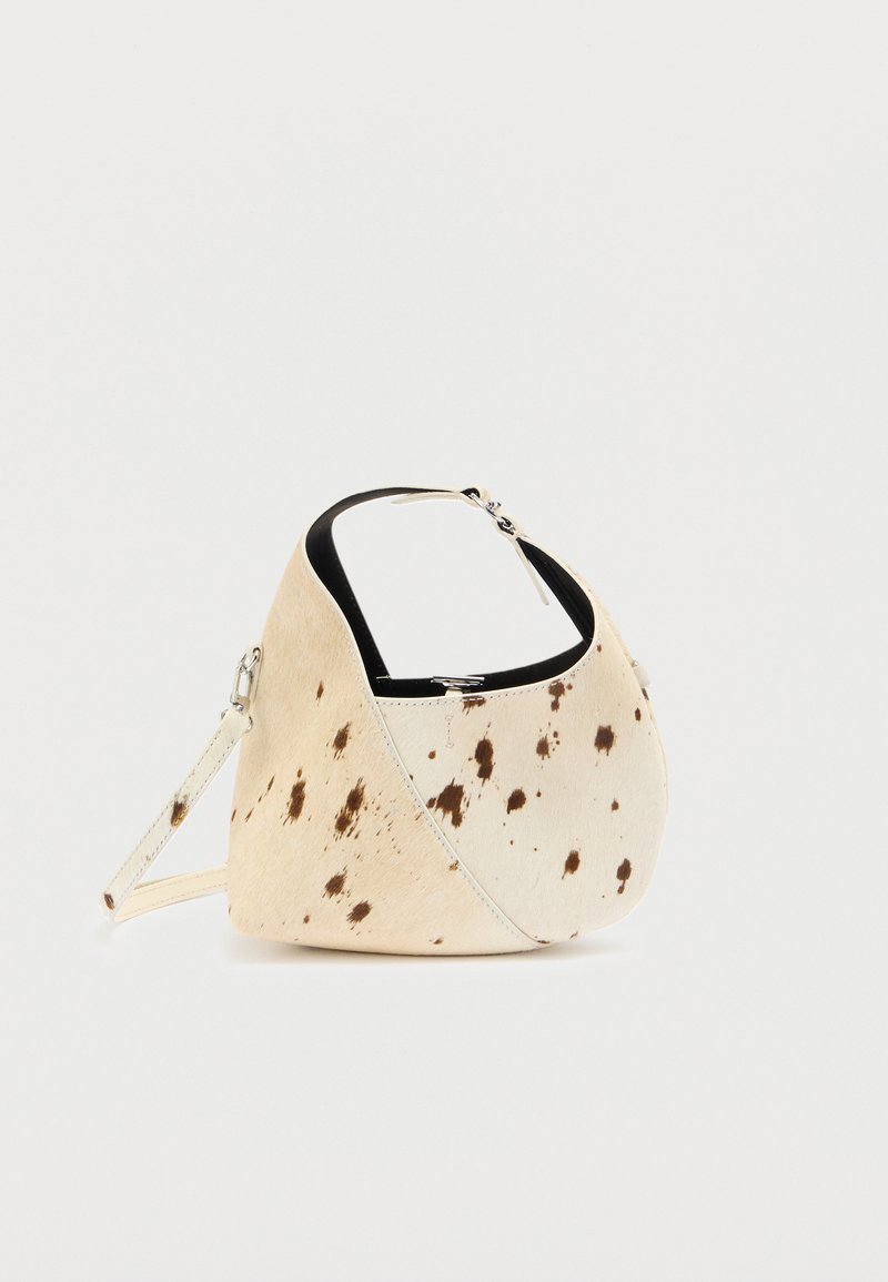Sac en cuir beige avec des taches marron foncé ; forme asymétrique unique et poignée courte ; présente une texture lisse et des accents en métal.