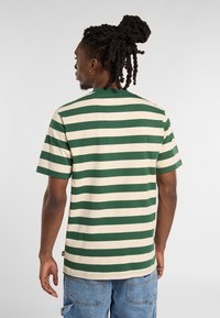 Green and cream striped t-shirt made of cotton, short sleeves, crew neckline, with a relaxed fit and a small tag on the side.