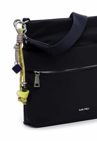 Granatowa torba z gładkiej, matowej tkaniny, wyposażona w solidny pasek, ozdobiona błyszczącym suwakiem i dekoracyjnymi zawieszkami w różnych kolorach.