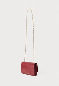 Pequeño bolso cruzado de piel roja con estampado de cocodrilo, con cadena dorada y logotipo dorado en la solapa frontal.