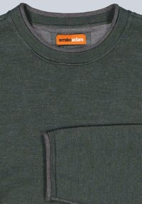 Dunkelgrüner Pullover mit Rundhalsausschnitt und strukturierter Strickoptik, mit einer Brusttasche und Kontrastnähten in hellerem Grau. Markenlabel sichtbar.