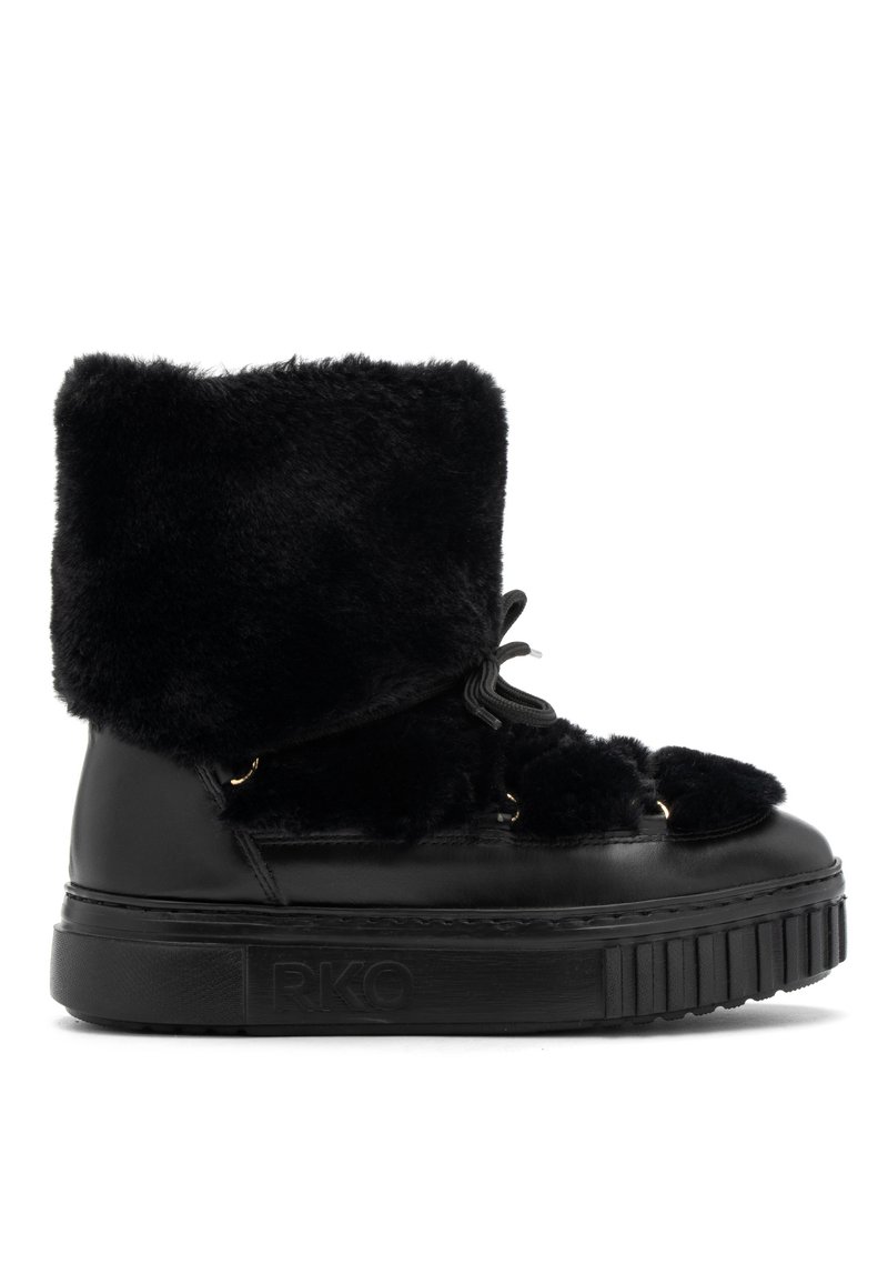 Botas de tobillo de cuero sintético negro con pelo sintético, con una suela gruesa negra, que presentan un cierre de cordones en el frente y acentos decorativos de pompones.