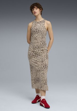 Sleeveless, leopard print dress in beige and brown with a fitted silhouette. Paired with red sneakers, white socks, and a simple earring.
