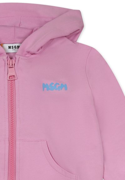 Felpa rosa chiaro con zip frontale, caratterizzata da un logo blu "MSGM". Il materiale sembra morbido con una texture liscia e tasche frontali.