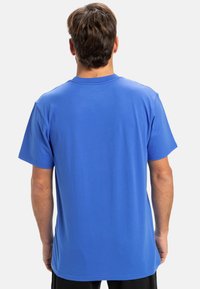 Modrá krátkopsová tričko vyrobené z jemnej bavlny. Má okrúhly výstrih a voľný strih, s hladkou textúrou a jednoduchým dizajnom.