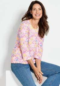 Bluse mit floralem Muster in Rosa, Gelb und Lila, mit rundem Ausschnitt und Dreiviertelärmeln, aus weichem Stoff.