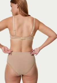 Beige bh en hooggewaiste slip met kantafwerking. De bh heeft verstelbare bandjes en een haak-en-oogsluiting aan de achterkant. Soepele textuur.