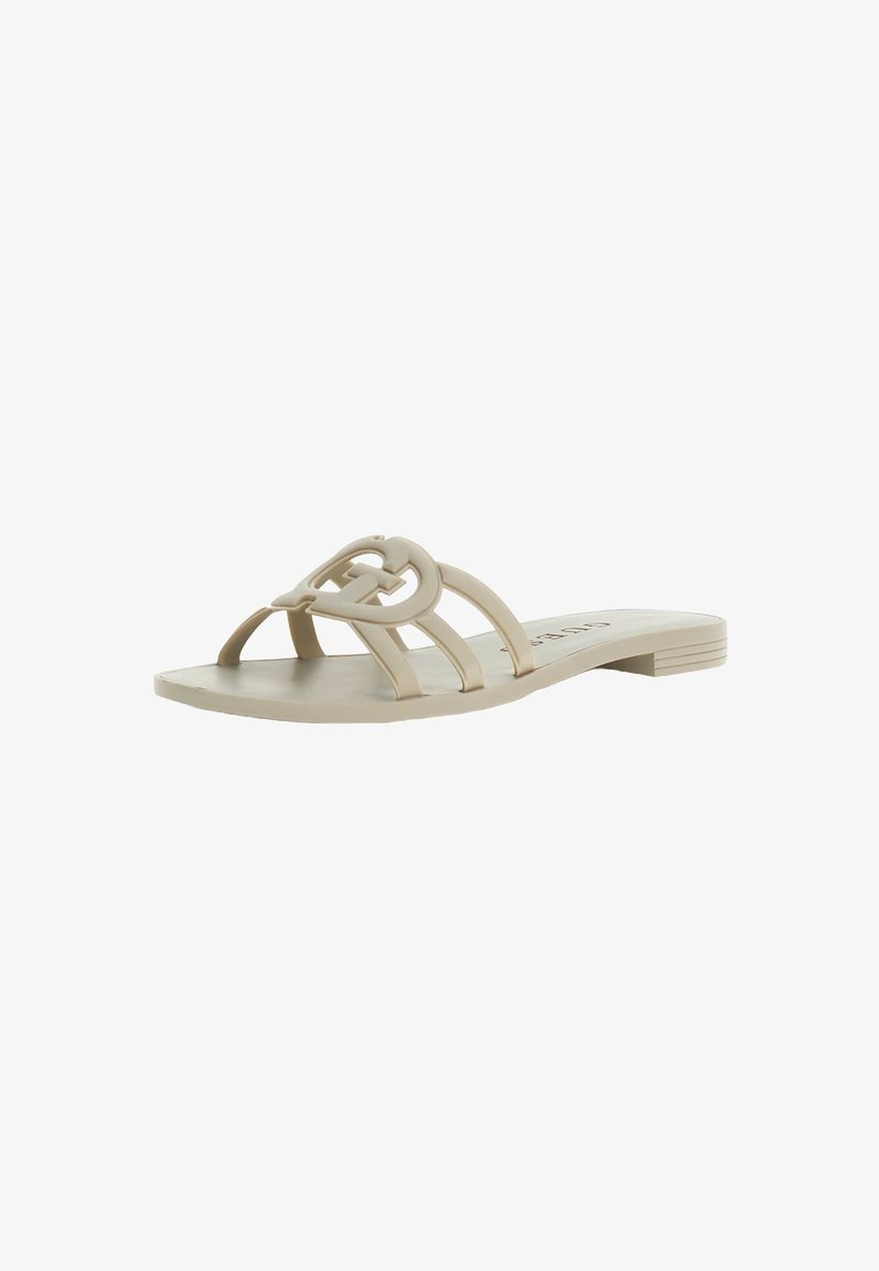 Beige flat slide sandal with three strap design and a decorative loop accent. Made of smooth material with a flat heel and no embellishments.