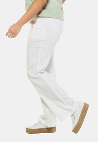 Vita linbyxor med rak passform och texturigt tyg. I kombination med vita plattformssneakers med en vävd sula.