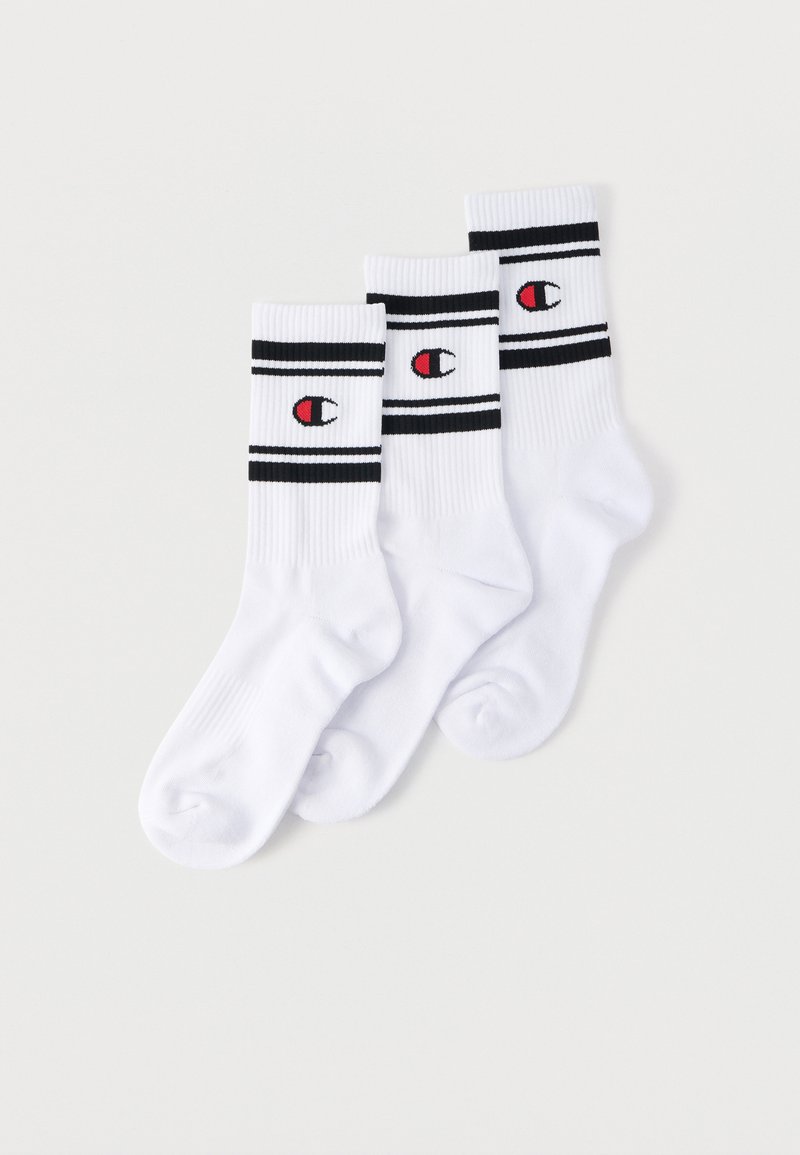 Trois paires de chaussettes blanches montantes avec des rayures noires et des logos Champion rouges et noirs sur un fond blanc.