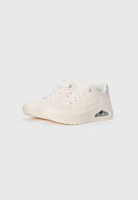 Scarpe sportive bianche con tomaia testurizzata, pannelli in rete e una cuscinetto d'aria visibile nella suola. Presentano lacci e una punta rinforzata.