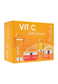 Das VIT C Hautpflege-Set in einer orangefarbenen Box enthält vier Artikel mit aufhellenden Reinigungsmitteln und Feuchtigkeitscremes, die für die Anwendungsschritte von 1 bis 4 gekennzeichnet sind.