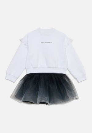 Weißer Pullover mit langen Ärmeln und Rüschen-Detail sowie "Karl Lagerfeld" Logo, kombiniert mit einem schwarzen mehrlagigen Tüllrock.