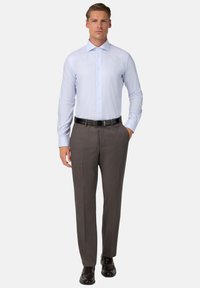 Camisa de vestir de manga larga azul clara con cuello puntiagudo, combinada con pantalones grises ajustados y zapatos de cuero negros. Cinturón negro incluido.