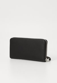 Portafoglio di pelle nera con una texture liscia, chiusura a zip tutto intorno e dettagli in metallo argentato. Forma rettangolare senza motivi visibili.